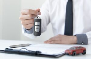 car salesman handing over keys to a customer