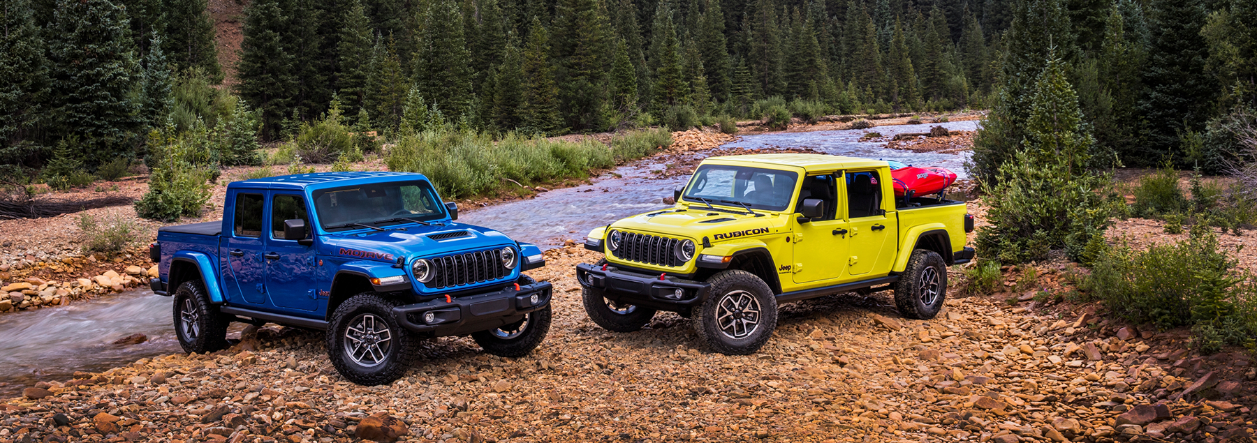 Two Jeep Gladiators near a creek. 